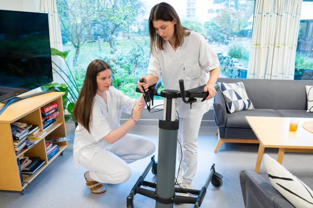 Jente med mørkt, langt hår og blå strikkaganser ser i kamera og smiler