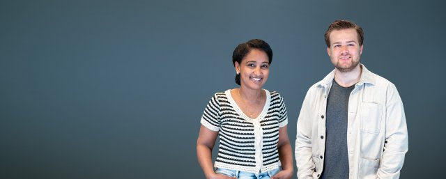Jente med mørkt hår i hestehale og gutt med kort mørkt hår ser i kamera og smiler