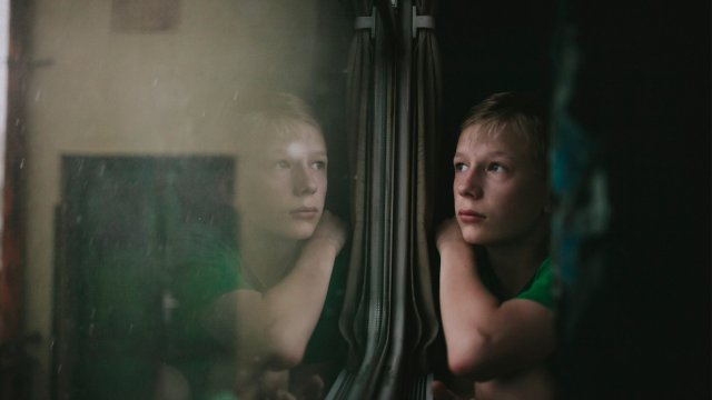 En ung gutt ser ut av et vindu