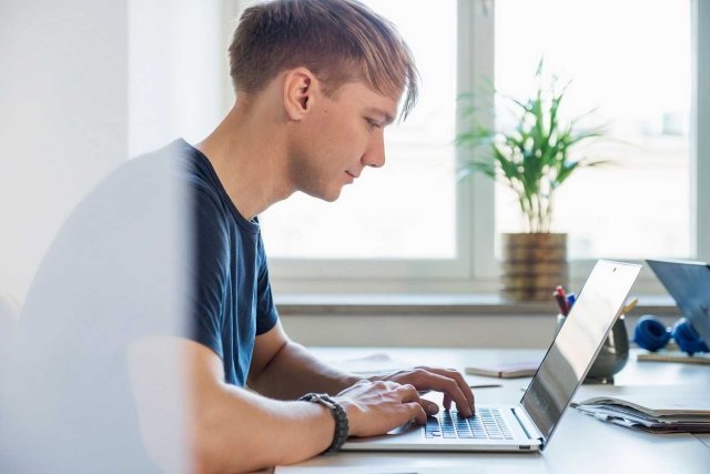 En ung student skriver på laptop