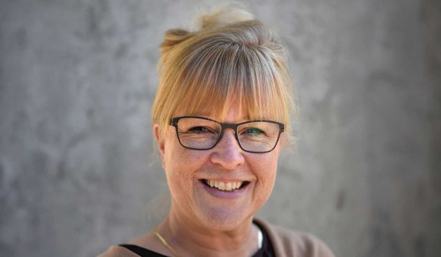 Smilende kvinne med blondt hår i hestehale