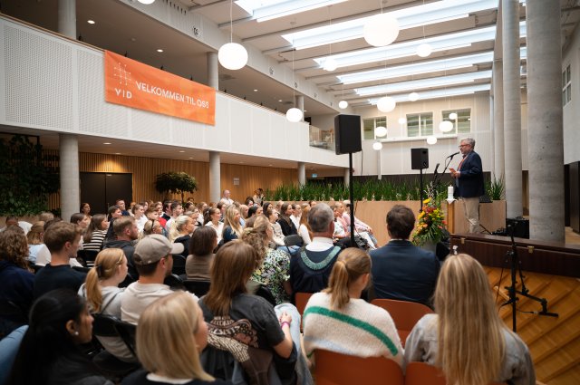 En stor gruppe studenter sitter samlet under studiestartsseremoni