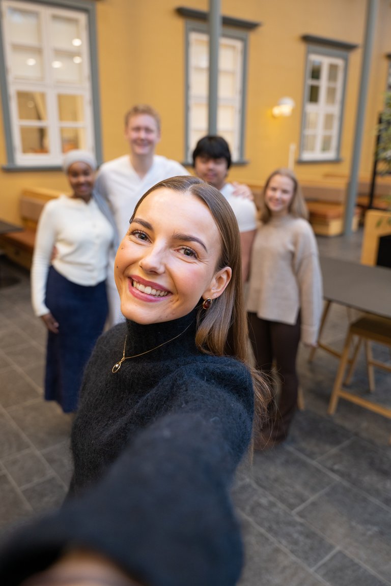 Portrett av Henrikke med medstudenter i bakgrunnen. 
