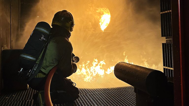 Bilde av Nicolaj som slukker brann i bygning.