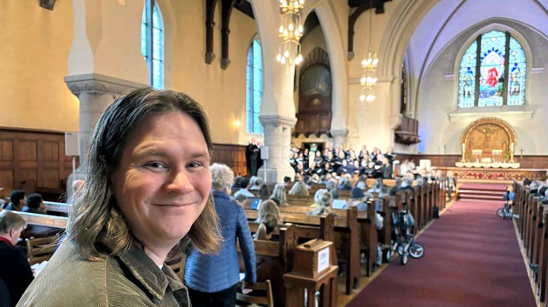 Portett av Tjelle med menigheten i bakgrunnen. 