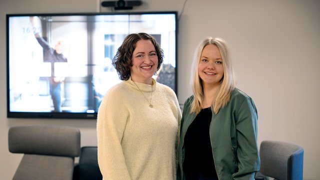 Portrett av Ann Eline og Synnøve stående foran et whiteboard på kontor.