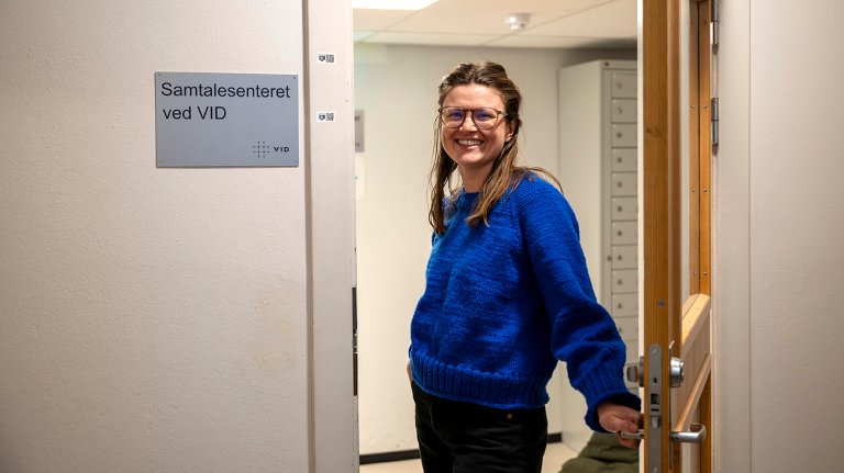 Sofie står i døråpningen til døra inn til samtalesenteret. 
