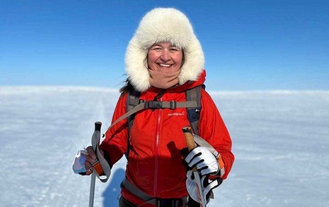 Portrett av Anna ute på skitur. Smiler mot kamera med stor pelslue på hodet.