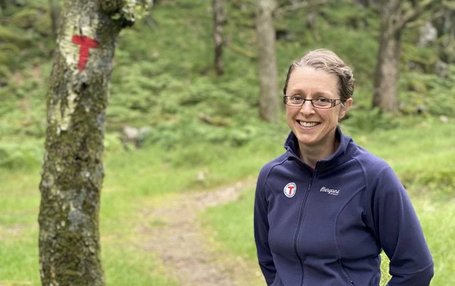 Portrett av Helen i skog med T i bakgrunnen.
