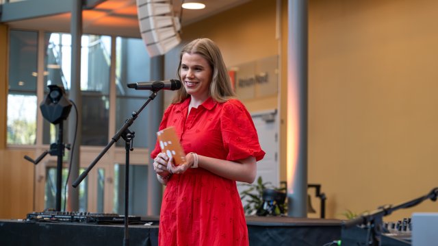 Britha står på en scene og snakker i en mikrofon