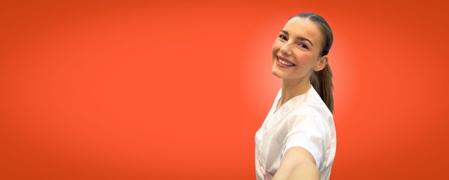 Jente med mørkt, langt hår ser i kamera og smiler