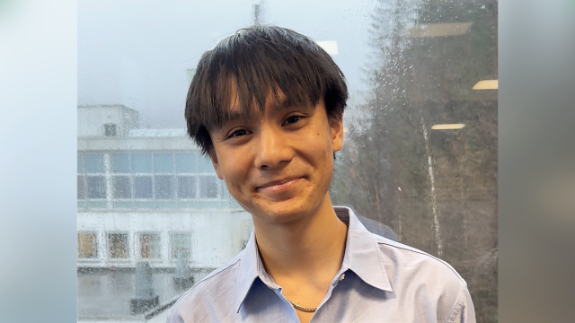 Young man with dark hair smiling at the camera
