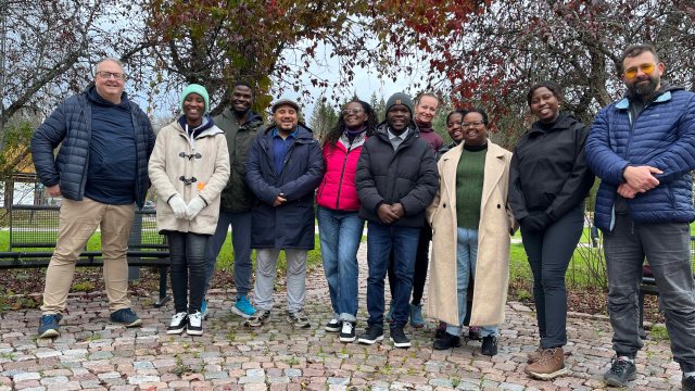 Eleven people in winter clothes looking at the camera and smiling