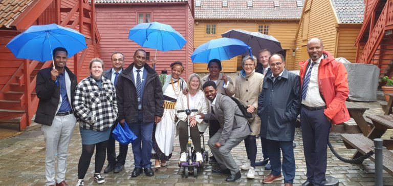 Gruppebilde ved gamle hus på bryggen i Bergen