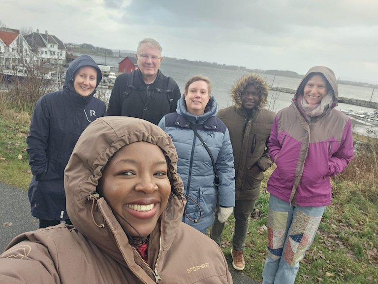 Group photo of people dressed in warm jackets somewhere along the Stavanger coast