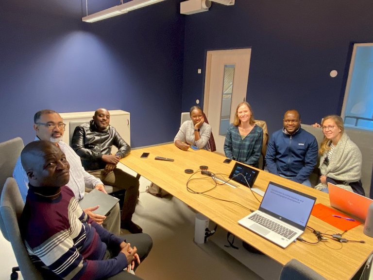 A group of people sitting around a table in a meeting room