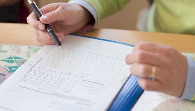 Hånd med penn skriver i en notatblokk