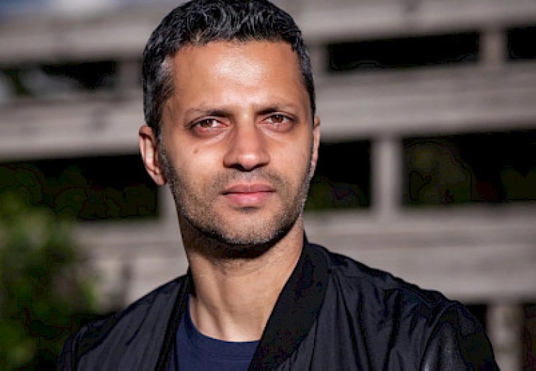 Man with dark short hair looking at the camera