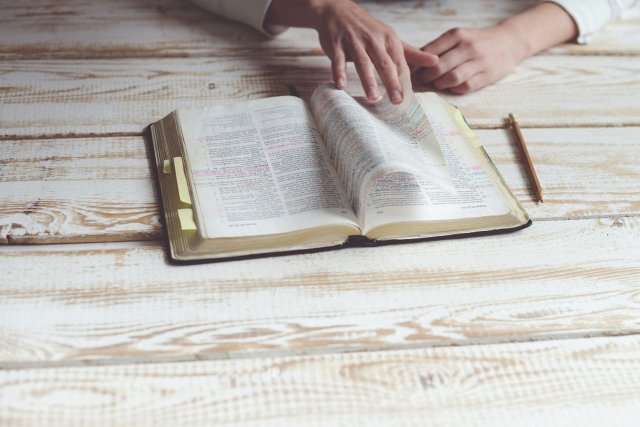 Nærbilde av hånd som blar i en bibel