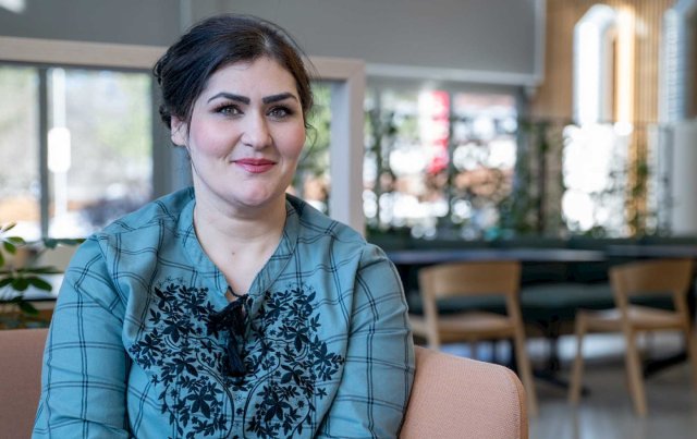 kvinnlig student som sitter foran biblioteket innendørs