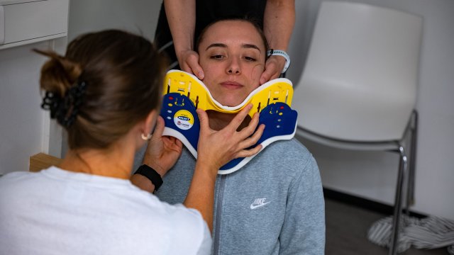 Student setter på en nakkestøtte på en annen student