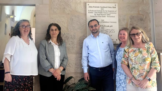 Fem mennesker foran en vegg ved John Patrick Cardinal Foley Hall