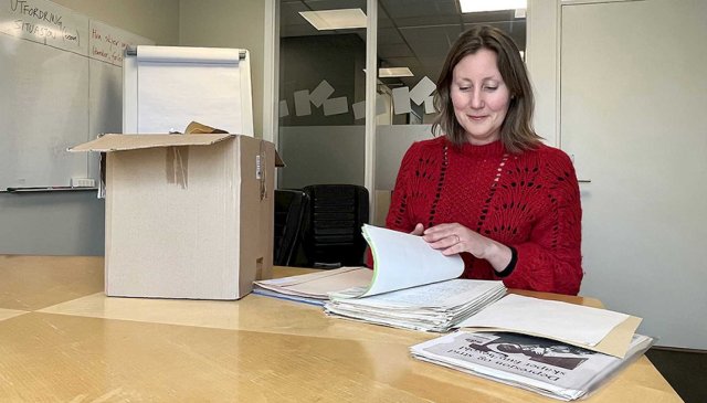 Dame sitter med arkivmapper