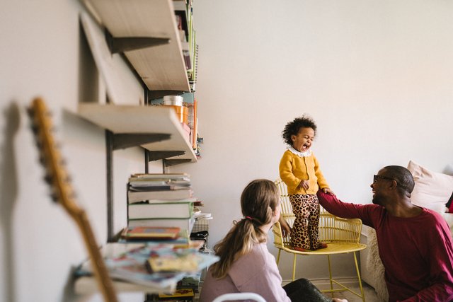 Barn og foreldre som leker inne i et hus