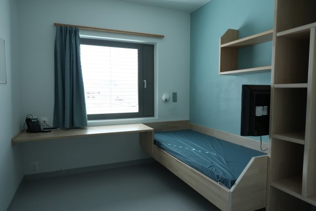 Et soverom med en seng og en pult