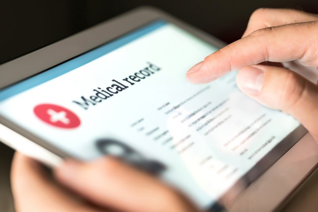Noen scroller på et nettbrett for å se en pasientjournal