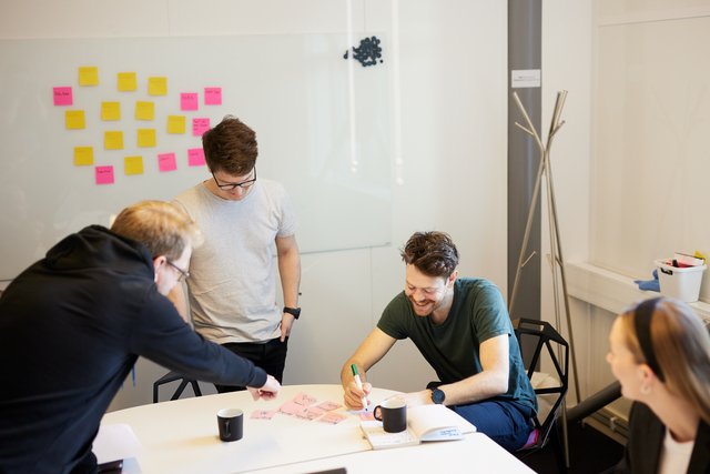 Studenter med en tavle full av post-it lapper