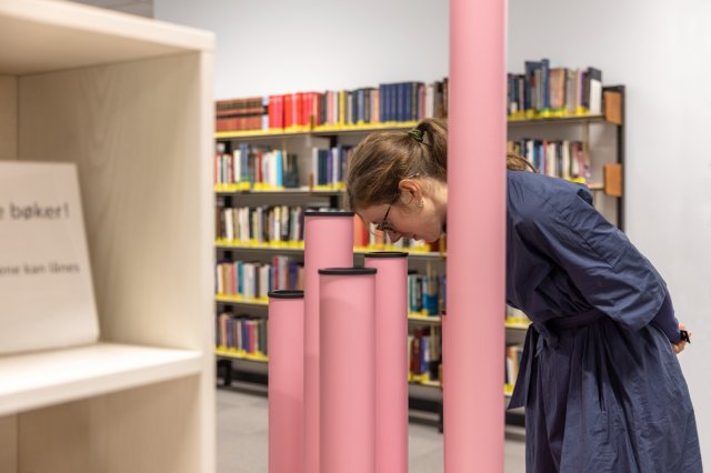 En dame kikker ned i rosa rør