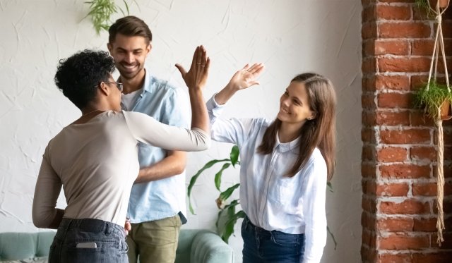 Tre studenter gir hverandre high-five