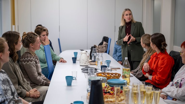 Gunhild står foran stipendiatene og snakker