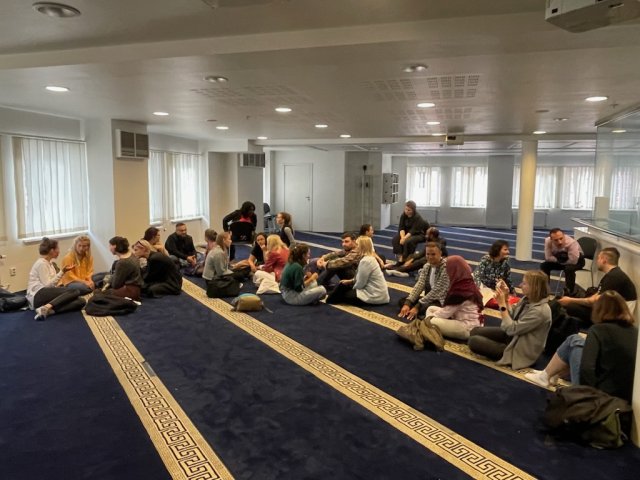 Deltakere sitter på gulvet i et tomt rom