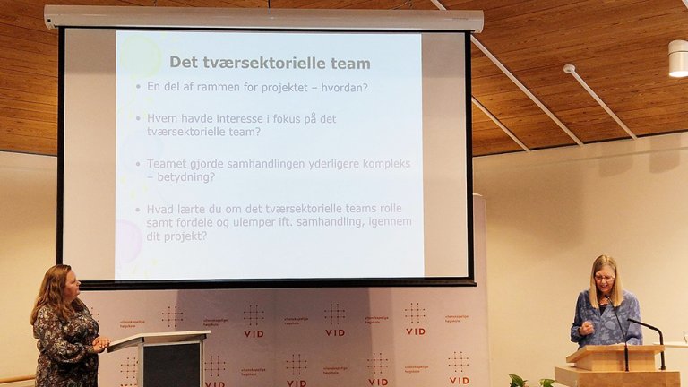 Bilde av Randi Skumsnes foran powerpoint i auditorie. 