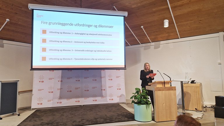 Sadeta Demic på talerstol foran powerpoint