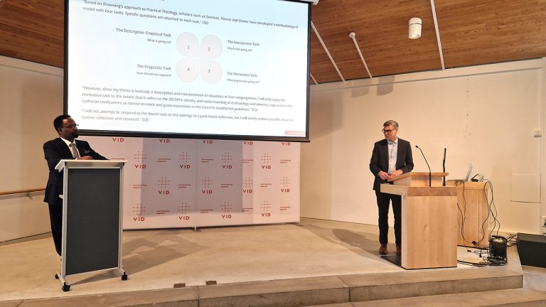 Teshome står på talerstol til venstre og snakker foran powerpointpresentasjon. Frank-Ole står foran talerstol til høyre.