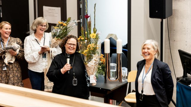 Fire blide damer på scenen som får blomster og tøyposer hvor det står Betanien på.