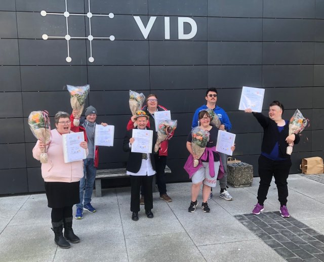 En gruppe studenter utenfor et skolebygg.