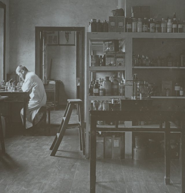 En mann sitter ved et skrivebord  i et laboratorie