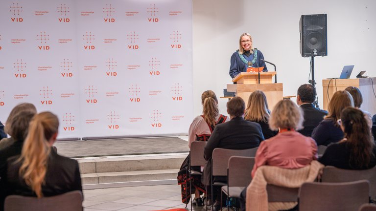 gunhild stående på scenen foran talerstol. 
