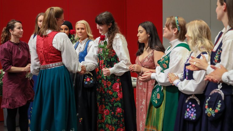 Festkledde mennesker på scene