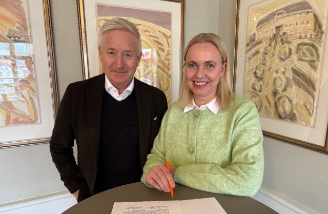 Mann og dame står sammen over en kontrakt