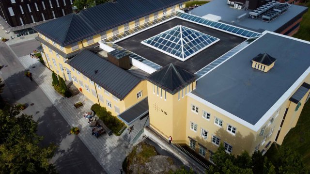 Dronebilde av gult campusbygg på VID Oslo