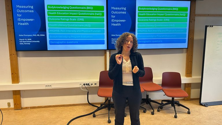 forsker snakker foran powerpoint-presentasjon