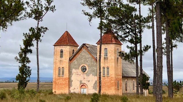 En murkirke innimellom trær.