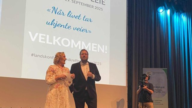 Kvinne og mann som leder et arrangement på en scene