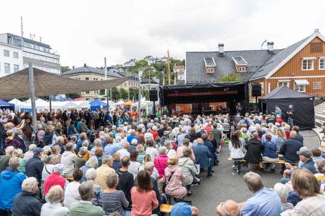 Et stort publikum foran en scene som står litt langt unna