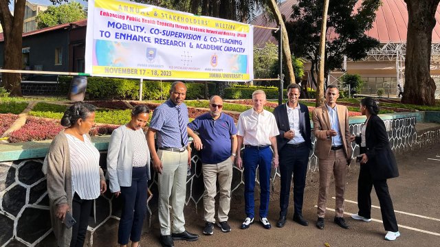 En gruppe mennesker står under et banner som opplyser om EPHAMs årlige møte på engelsk.